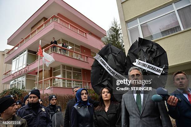Turkish police stand by as Kadir Canpolat, the head of Ankara Ottoman associations speaks to supporters gathered outside the Ankara offices of the...