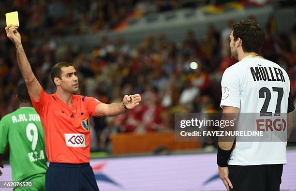 Germany's Michael Muller receives a yellow card during the 24th Men's Handball World Championships preliminary round Group D match between Saudi...