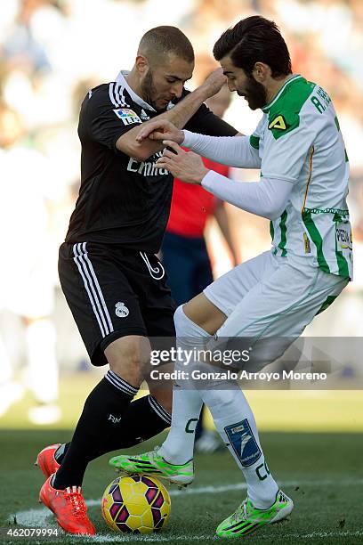 Karim Benzema of Real Madrid competes for the ball with Jose Angel Crespo of Cordoba CF during the La Liga match between Cordoba CF and Real Madrid...