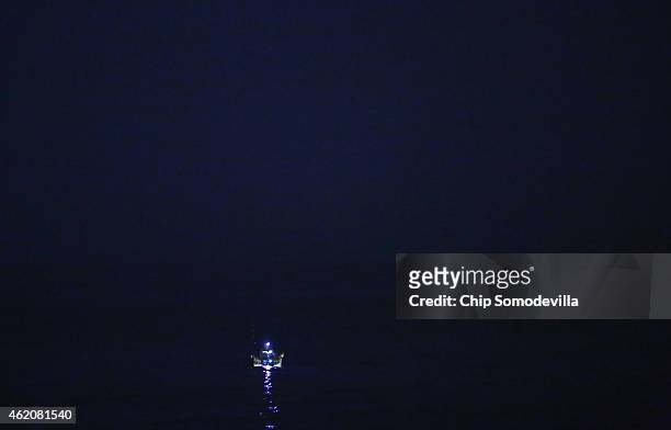 Fisherman uses a floating chair to paddle out into the Carribean to do some night fishing just off of the historic Maelcon oceanfront drive January...