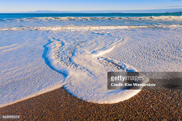 foamy wave patterns, pebble beach - westerskov stock pictures, royalty-free photos & images