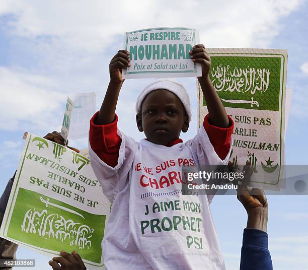 People hold placards during a protest against the printing of satirical sketches of the Prophet Mohammed by French magazine Charlie Hebdo, on January...