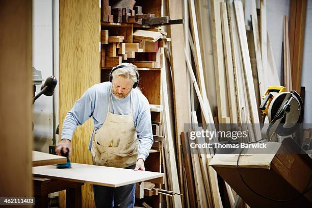 male woodworker in woodshop sanding cabinet panel - thomas sanders stock pictures, royalty-free photos & images