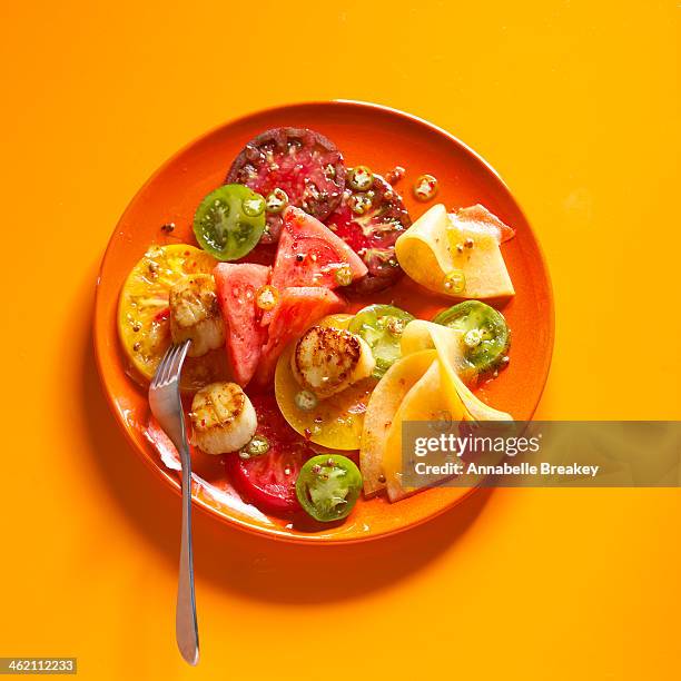 salad of fresh tomato, melon and scallops - orange backgrounds stock pictures, royalty-free photos & images