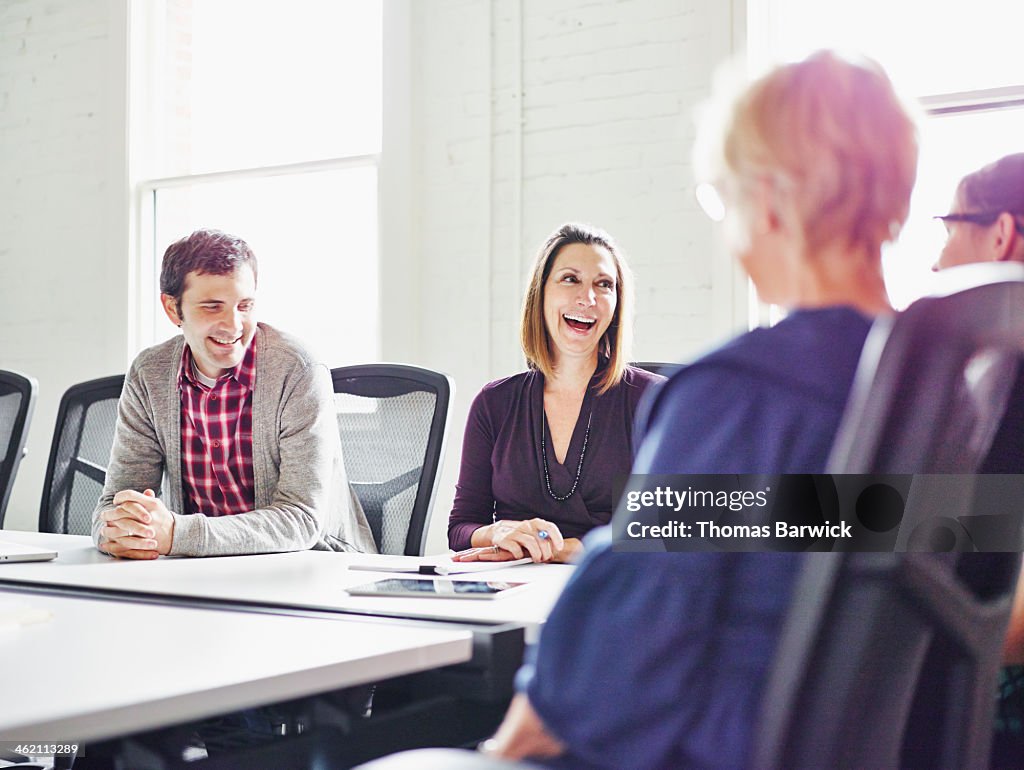 Laughing group of coworkers in conference room