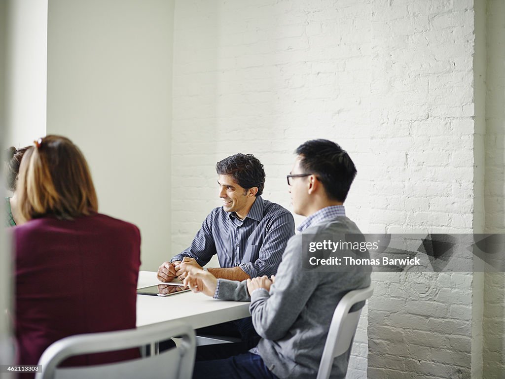 Coworkers in discussion at conference room table