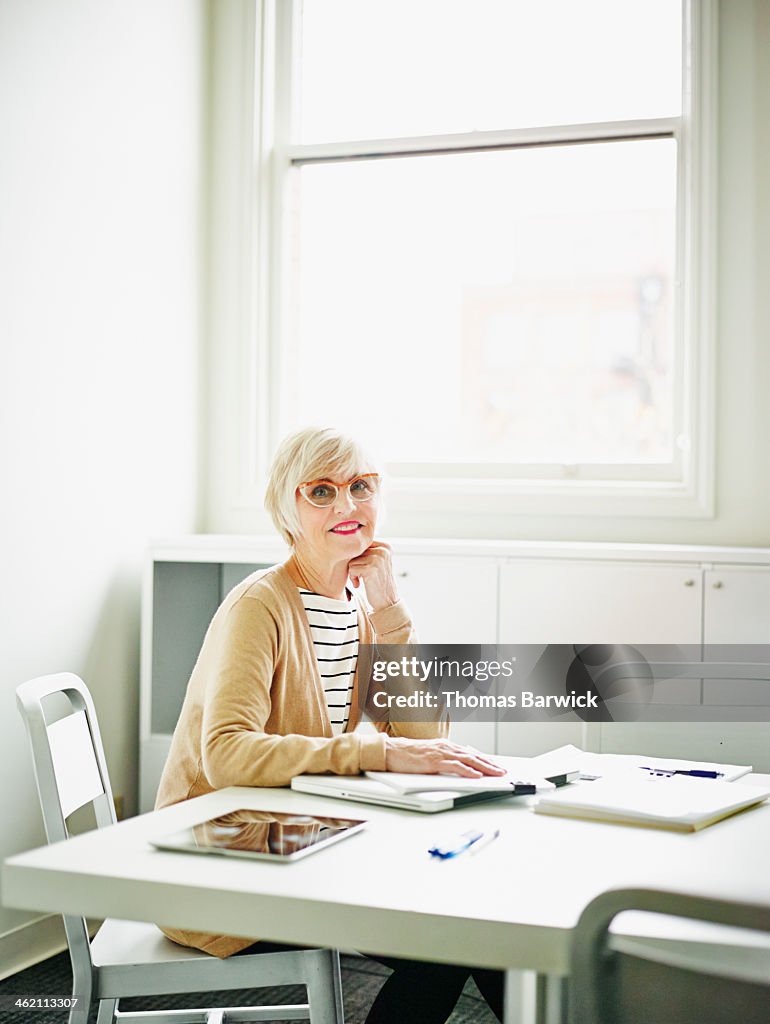 Smiling senior businesswoman sitting in office