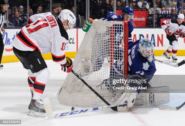 Jonathan Bernier of the Toronto Maple Leafs reaches out for a poke check as Stephen Gionta of the New Jersey Devils battles for the puck during NHL...