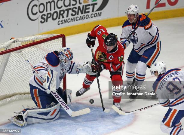 Jonathan Toews of the Chicago Blackhawks shoots against Devan Dubnyk of the Edmonton Oilers as Martin Marincin and Ryan Nugent Hopkins defend at the...