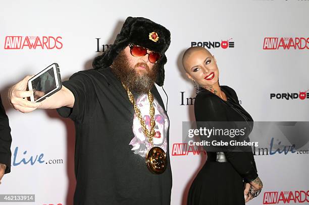 Adult film director Ivan takes a cell phone picture with adult film actress Christy Mack as they arrive at the 2015 Adult Video News Awards at the...