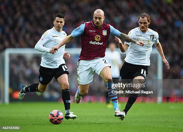 Alan Hutton of Aston Villa takes on Ian Harte and Shaun MacDonald of Bournemouth during the FA Cup Fourth Round match between Aston Villa and AFC...