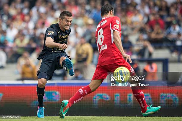 Dante Lopez of Pumas kicks the ball as Aaron Galindo tries to block of Toluca defends during a match between Pumas UNAM and Toluca as part of 3rd...