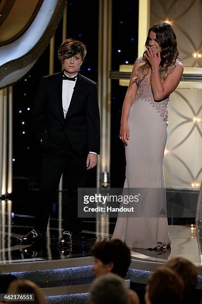 In this handout photo provided by NBCUniversal, Host Amy Poehler and Miss Golden Globe Sosie Bacon speak onstage during the 71st Annual Golden Globe...