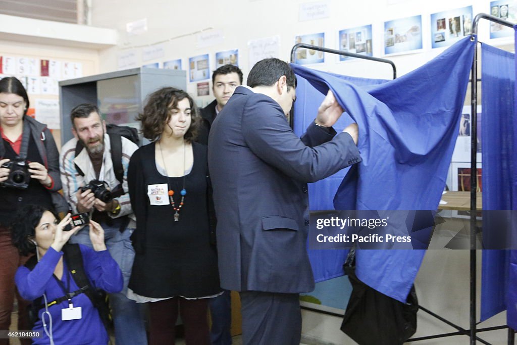 Alexis Tsipras enters the voting booth to cast his vote.