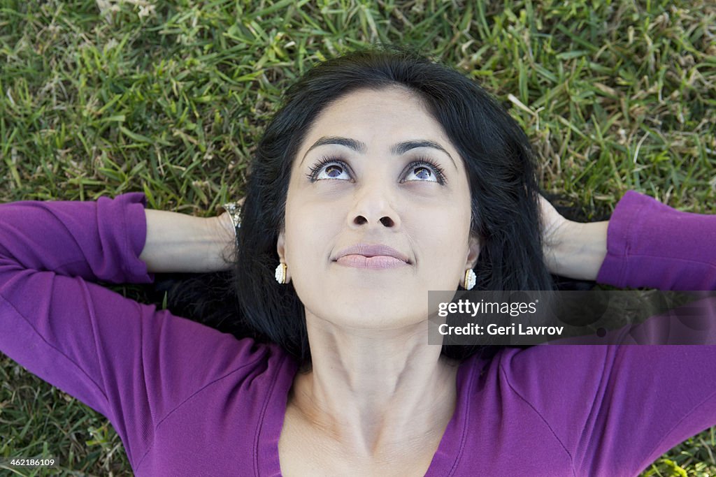 Indian woman relaxing on grass