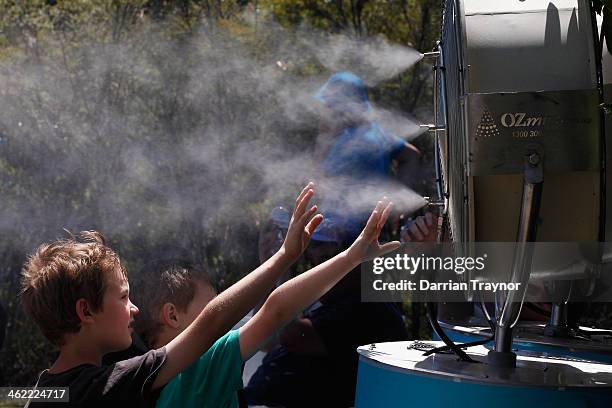 Fan cools down in front of a mister during day one of the 2014 Australian Open at Melbourne Park on January 13, 2014 in Melbourne, Australia.