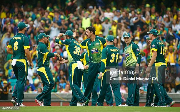 Mitchell Starc of Australia celebrates with teammates after taking the wicket of Shikhar Dhawan of India during the One Day International match...