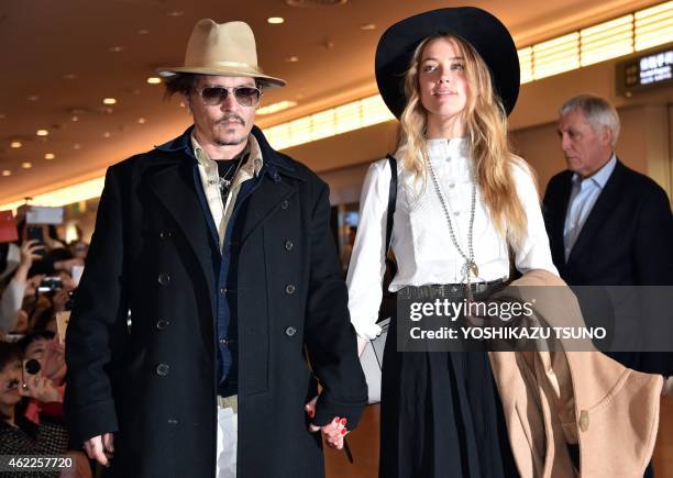 Actor Johnny Depp , accompanied by his fiancee US actress and model Amber Heard , arrive at Tokyo International Airport on January 26, 2015 for the...