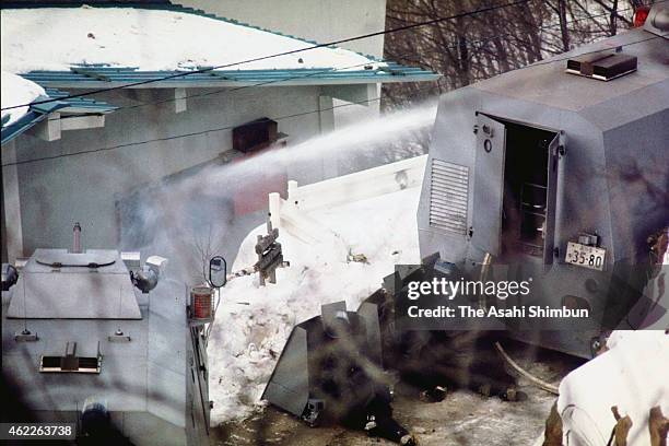 The police hoses water at the Asama Sanso holiday lodge where the United Red Army is taking a hostage on February 24, 1972 in Karuizawa, Nagano,...