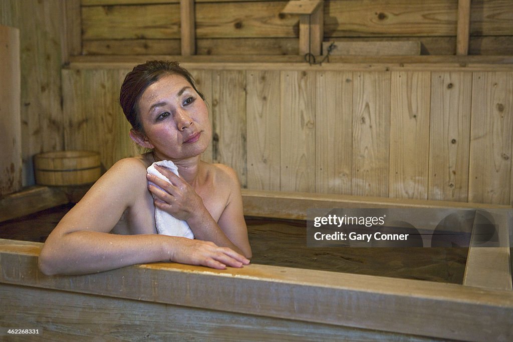 Woman enjoys soaking in hot bath