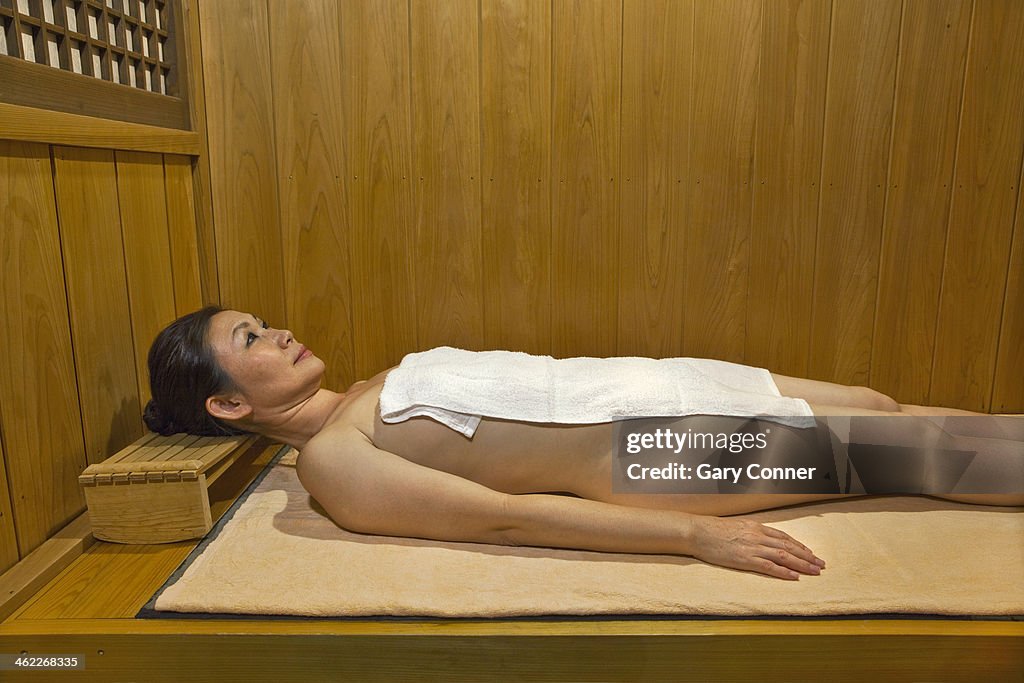 Woman relaxes in sauna
