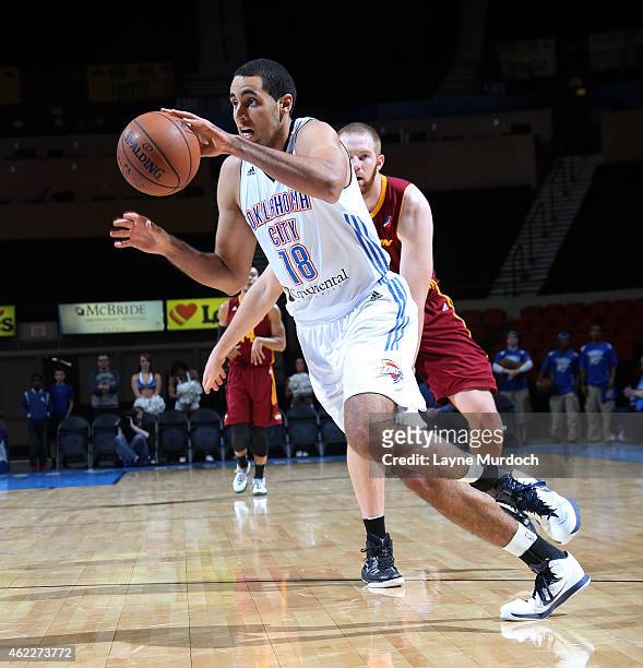 Grant Jerrett of the Oklahoma City Blue drives against Alex Kirk of the Canton Charge during an NBA D-League game on January 23, 2015 at the Cox...