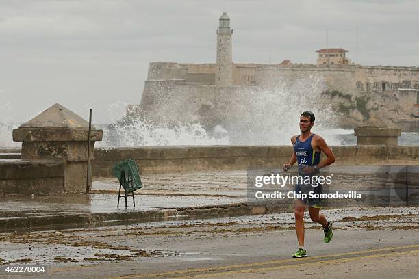 With the Castillo de los Tres Reyes Magos del Morro rising in the background, a participant in the Havana Triathlon competes in the running portion...