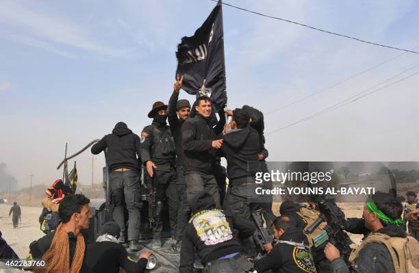 Iraqi government forces celebrate while holding an Islamis Sate group flag after they claimed they have gained complete control of the Diyala...
