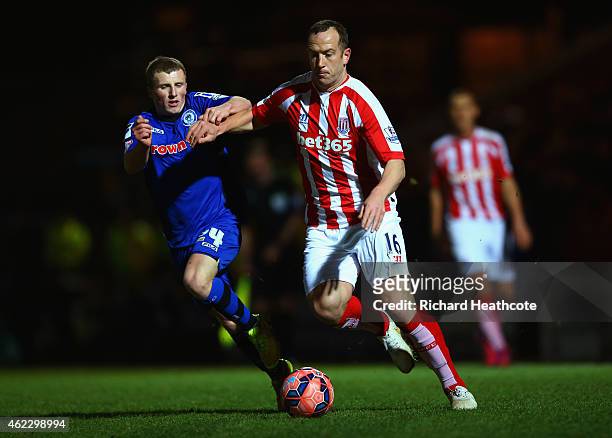 Jamie Allen of Rochdale and Charlie Adam of Stoke City battle for the ball during the FA Cup fourth round match between Rochdale and Stoke City at...