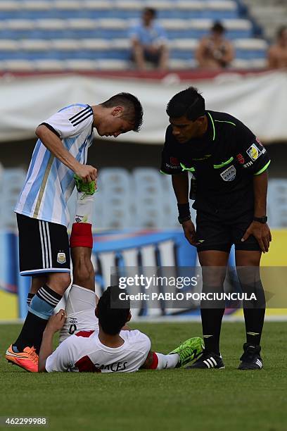 Argentina's midfielder Nicolas Tripichio helps Peru's midfielder Renzo Garces during the South American U-20 football match at the Centenario stadium...