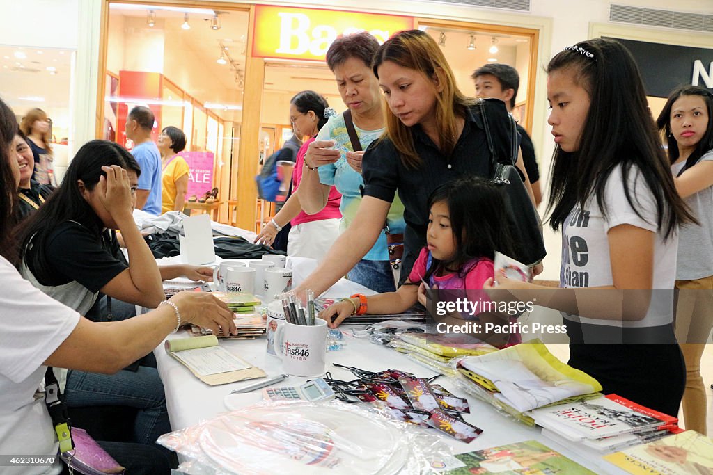 Filipino Catholics buy a memorabilia in the "Tour of Papal...