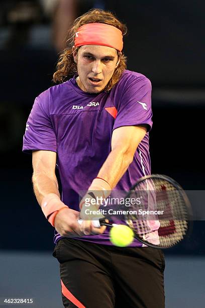 Lukas Lacko of Slovakia plays a backhand in his first round match against Novak Djokovic of Serbia during day one of the 2014 Australian Open at...