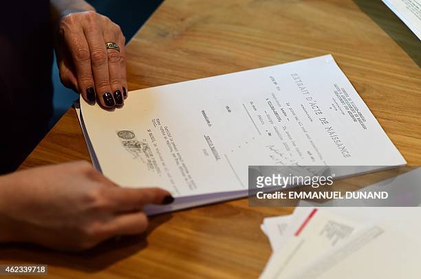 Monica Van Langendock displays her birth certificate during an interview in Kontich, Belgium on January 9, 2015. Monica Van Langendock was born...