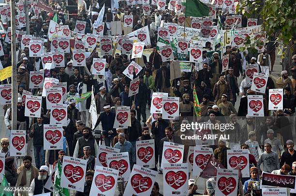 Pakistani Islamists carry placards that read "Muhammad" as they gather during a protest against the printing of satirical sketches of the Prophet...