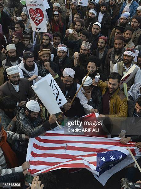 Pakistani Islamists tear French and US flags during a protest against the printing of satirical sketches of the Prophet Muhammad by French magazine...