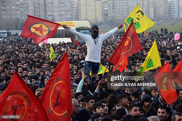 Man holds a flag of the Kurdish Worker's Party and a poster flag of jailed kurdish leader and PKK founder Abdullah Ocalan during a rally on January...