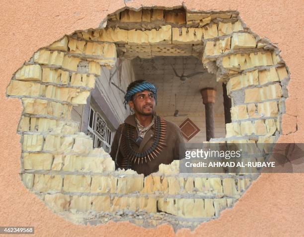 An Iraqi Sunni fighter checks house that was damaged during clashes against Islamic State group fighters in the village of Sharween in Diyala...