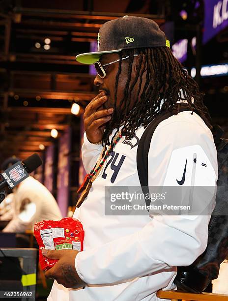 Marshawn Lynch of the Seattle Seahawks eats Skittles as he addresses the media at Super Bowl XLIX Media Day Fueled by Gatorade inside U.S. Airways...