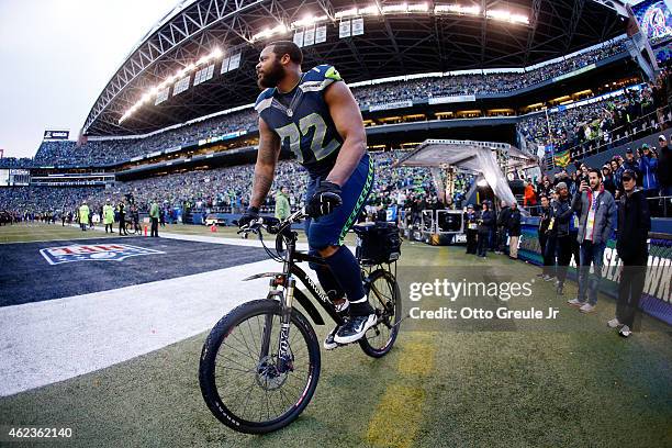 Michael Bennett of the Seattle Seahawks rides a police bike after the Seahawks 28-22 overtime victory against the Green Bay Packers during the 2015...