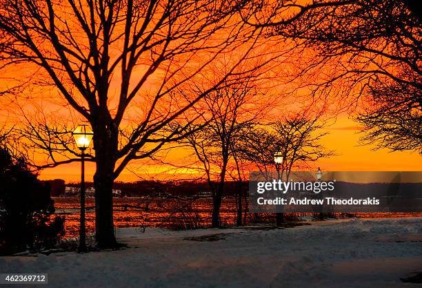 The sun sets over the Long Island Sound after a severe winter storm passed through on January 27, 2015 in Stony Brook, New York. Snow levels from...