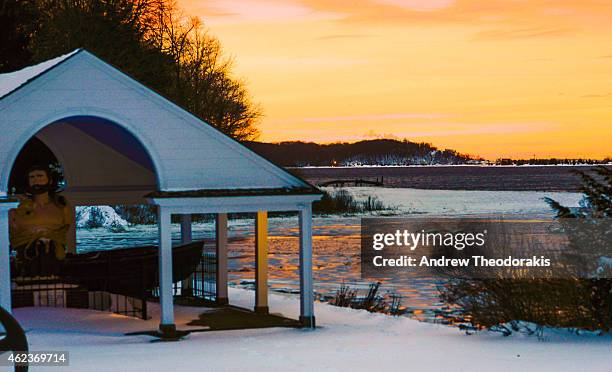 The sun sets over the Long Island Sound after a severe winter storm passed through on January 27, 2015 in Stony Brook, New York. Snow levels from...