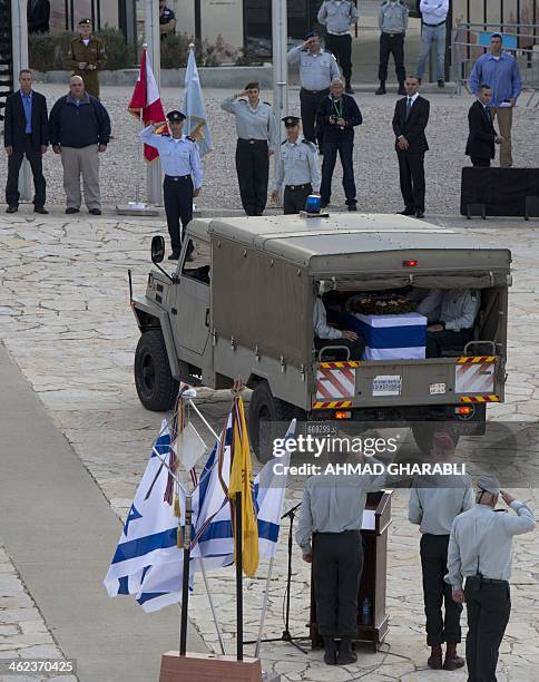 Gilad , Omri , the sons of the former Israeli prime minister Ariel Sharon watch as his flag draped coffin sits inside a vehicle, as it stops at the...