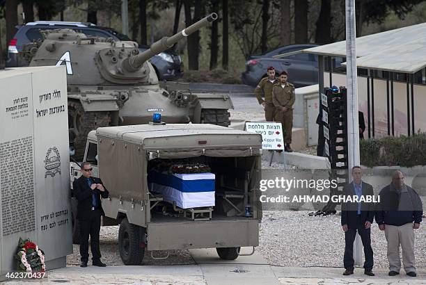 Gilad and Omri , the sons of the former Israeli prime minister Ariel Sharon watch as his flag draped coffin sits inside a vehicle, as it stops at the...