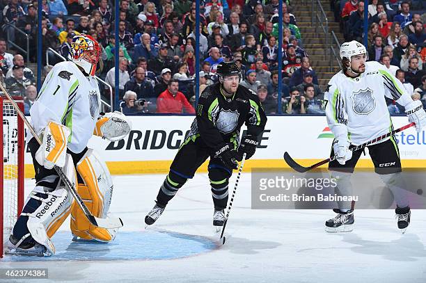 Phil Kessel of the Toronto Maple Leafs and Team Foligno skates between goaltender Roberto Luongo of the Florida Panthers and Team Toews and Justin...