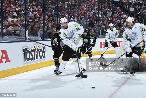 Patrice Bergeron of the Boston Bruins and Team Toews passes the puck from behind the net as Claude Giroux of the Philadelpha Flyers and Team Foligno,...