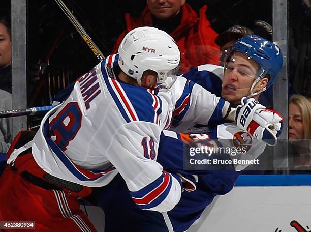 Anders Lee of the New York Islanders is hit into the boards by Marc Staal of the New York Rangers during the third period at the Nassau Veterans...