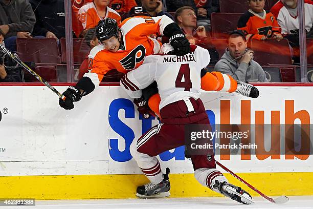 Brayden Schenn of the Philadelphia Flyers is hit by Zbynek Michalek of the Arizona Coyotes in the third period at Wells Fargo Center on January 27,...