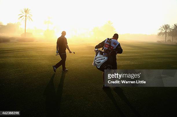 Stephen Gallacher of Scotland and his caddie Damian Moore walk up the 10th fairway during the pro-am ahead of the Omega Dubai Desert Classic on the...
