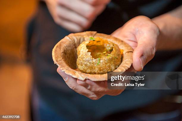 Flanking the pavement, under a tent of blue plastic, Jetendra Pandit and his wife are making puchka, savoury bombs of semolina pastry filled with...