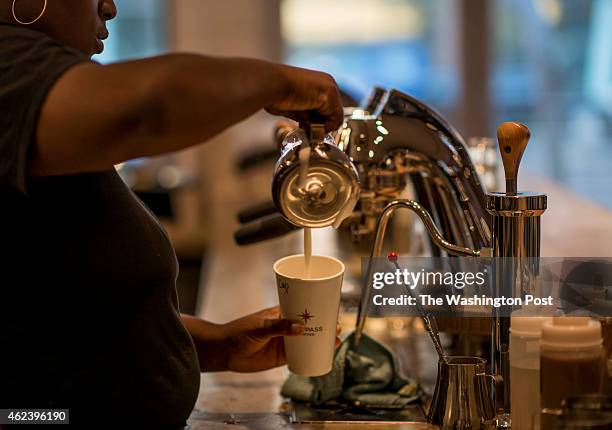 On Opening Day of Compass Coffee barista Brittany Pugh makes and serves a latte in the Shaw neighborhood of Washington, DC Monday, September 22, 2014.